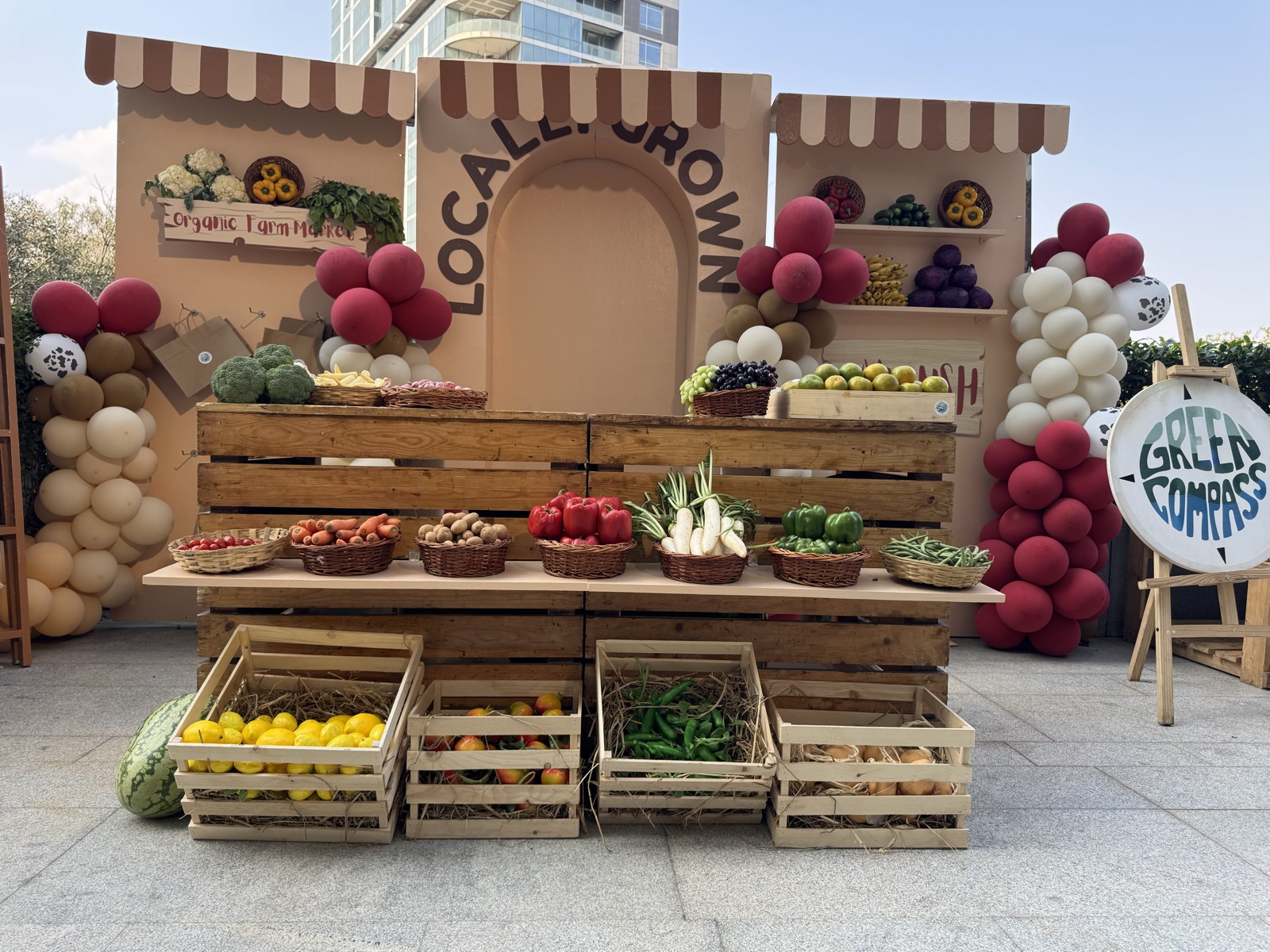 A pretend farmers' market stall stocked with real fruit and vegetables in wooden crates